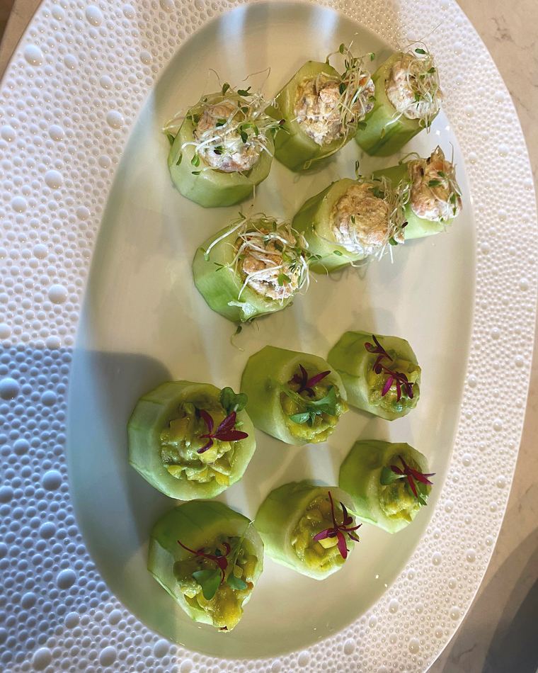Cucumber rounds with herb cream on a white oval plate