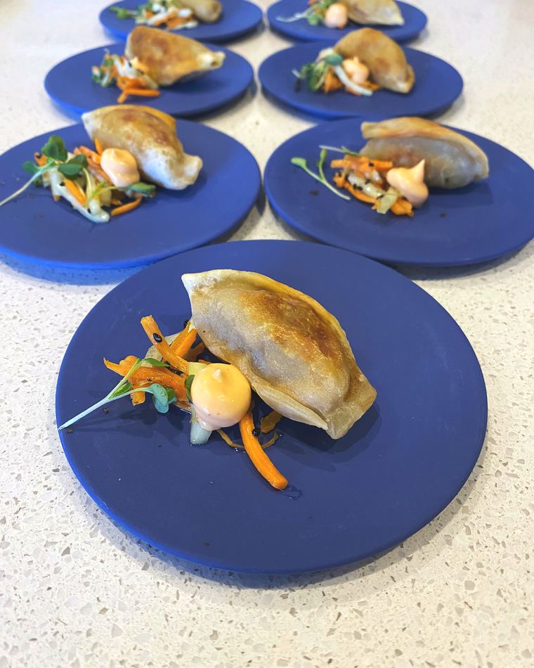 Dumplings plated on cobalt blue plates for cocktail service
