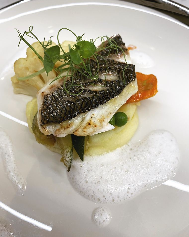 Crisp-skinned sea bass on fennel with a light champagne foam