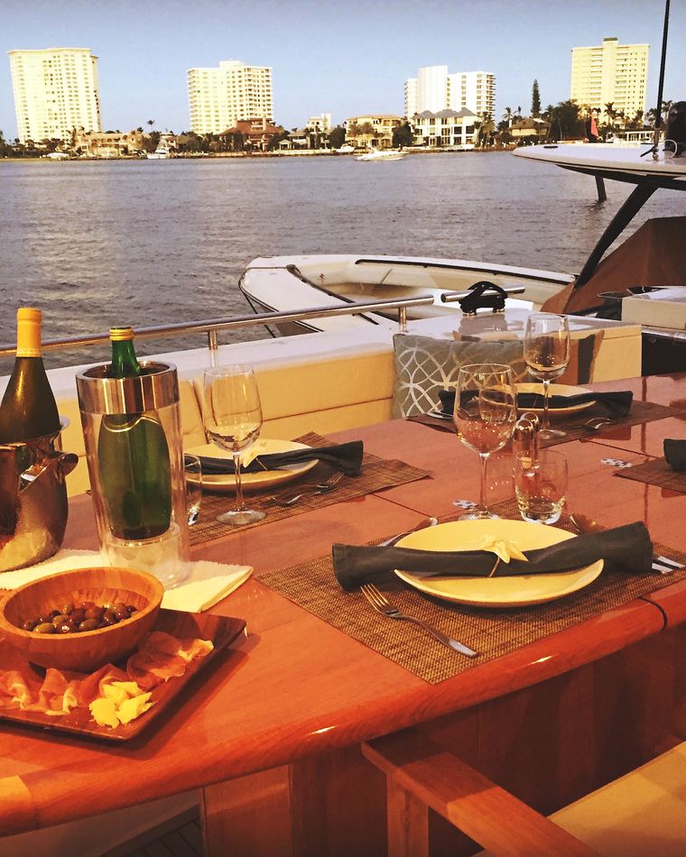 The aft deck table set for dinner with champagne at golden hour