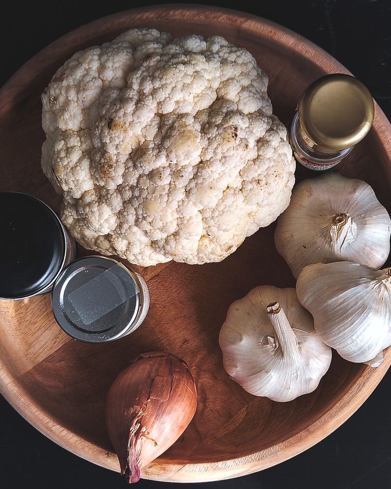 Cauliflower, garlic and shallot in a wooden bowl