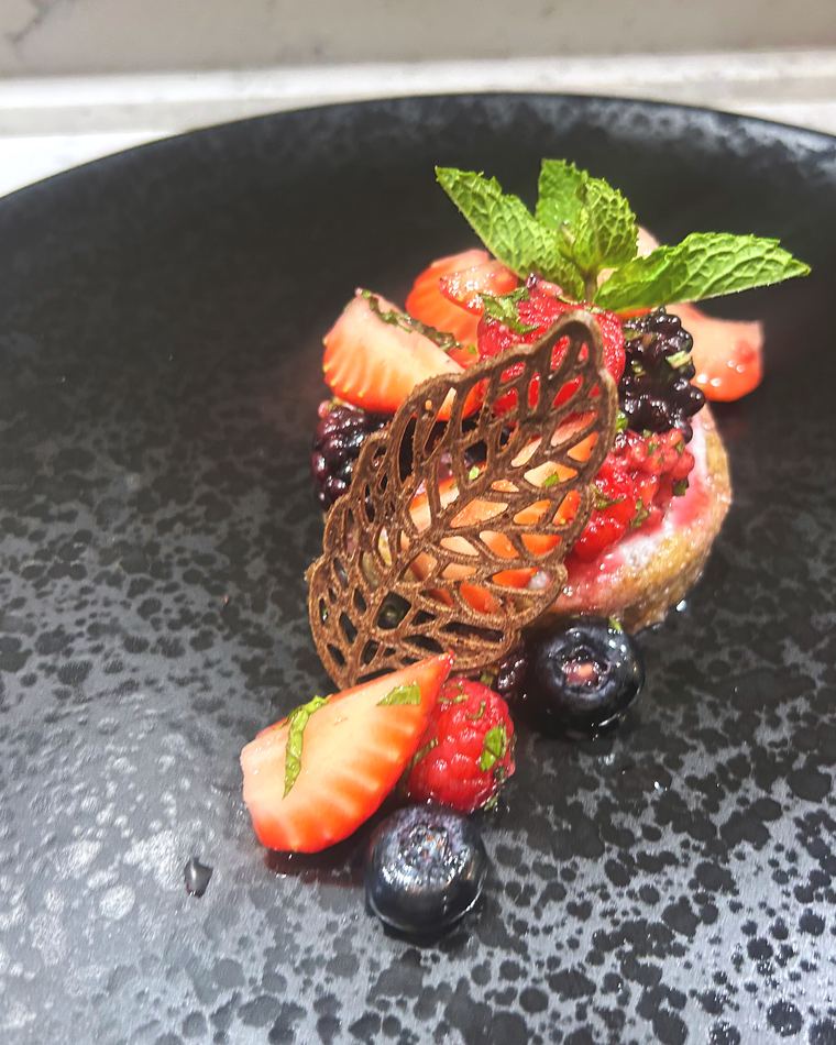 Berries under a chocolate lace tuile with strawberry and mint