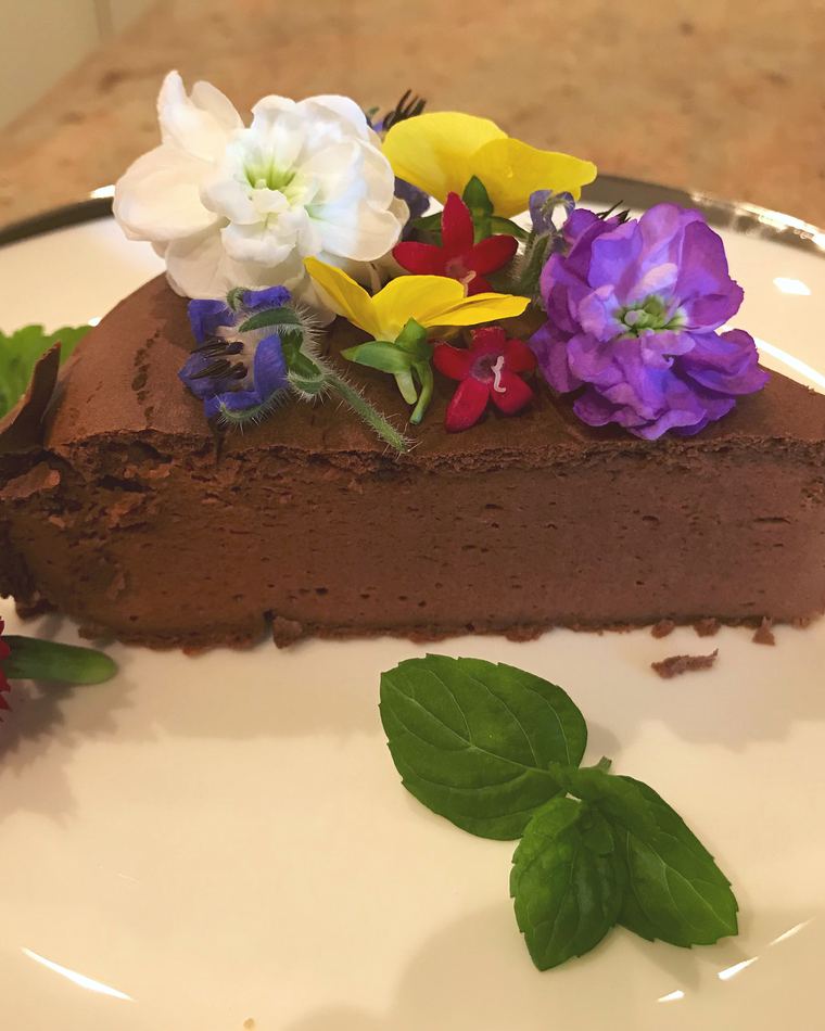 A slice of chocolate terrine dressed with garden flowers